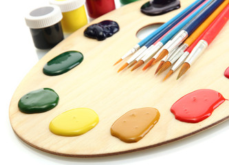 wooden art palette with  paint and brushes.isolated on white