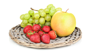 ripe sweet fruits and berries on wicker mat isolated on white