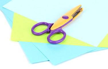 Colorful zigzag scissors with color paper isolated on white