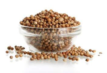 Heap coriander seeds in glass bowl isolated on white