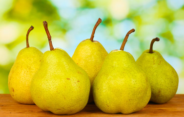 Ripe pears on colorful green background