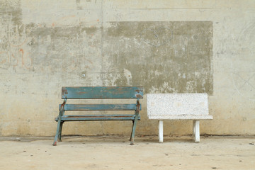 Two bench on dirty concrete wall background