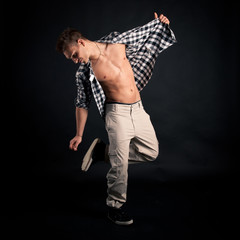 Studio portrait of dancing young man with plaid shirt 