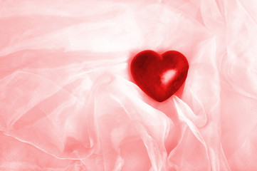 Love concept - red heart on pastel red organza