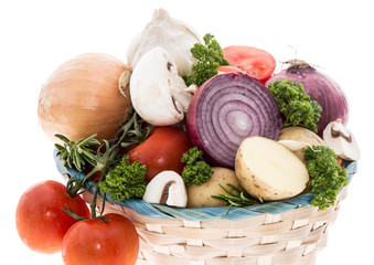 Basket with vegetables on white