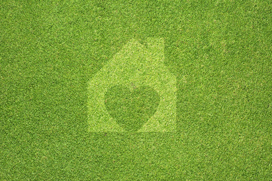 Heart of home on green grass texture and  background