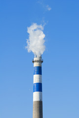 industrial smoke from chimney on blue sky