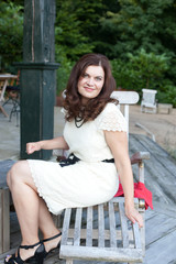 Young beautiful woman sitting in garden restaurant summer