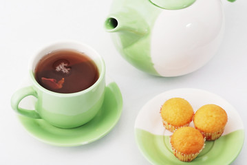 Tea being poured into tea cup isolated on a white background