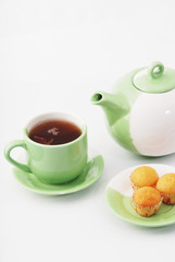 Tea being poured into tea cup isolated on a white background