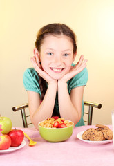 little beautiful girl have a breakfast on beige background