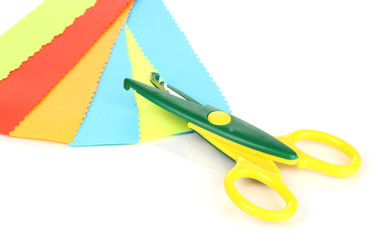 Colorful zigzag scissors with color paper isolated on white