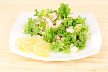 Delicious marinated shrimp in plate on bamboo mat