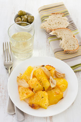 potato on the white plate with olive, bread and white wine
