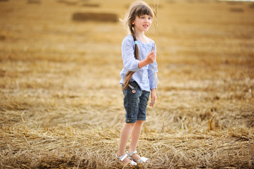 Naklejka na ściany i meble Little girl holding wheat spikelet