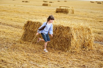 Naklejka na ściany i meble Little girl running around on a field