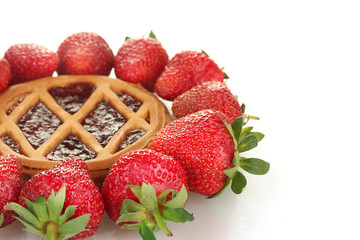 Tart garnished with strawberry on white background close-up