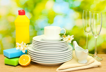 empty clean plates, glasses and cups with dishwashing liquid,