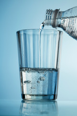 Pouring a water from the bottle into the glass