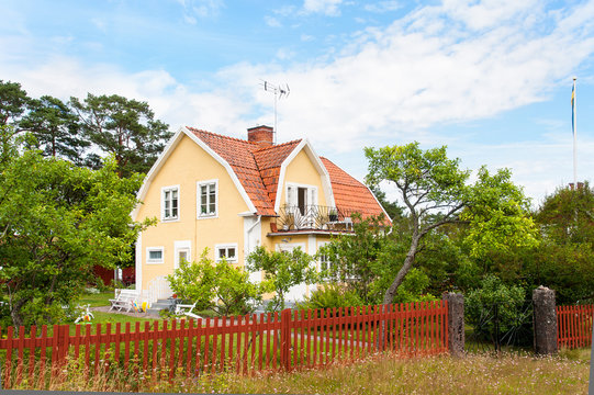 Typisches schwedisches Holzhaus in gelber Fabfassung
