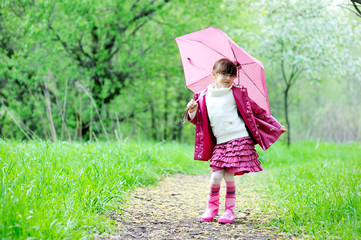 Kid girl posing outdoors with pink umbrella