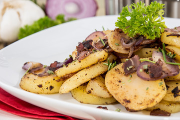 Portion of fried Potatoes with raw ingredients