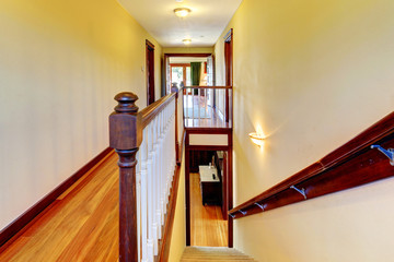 Stairway with hardwood floor and wood railing.