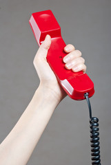 Red old fashioned style telephone handset receiver and arm