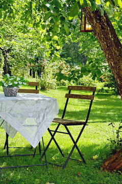 Idyllic setting of a small coffee table and wooden chair