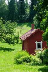 Red idyllic cottage in summer landscape