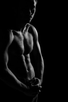 Black and white image of shirtless muscular man posing