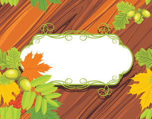 Acorns, rowan and maple leaves on the wooden background