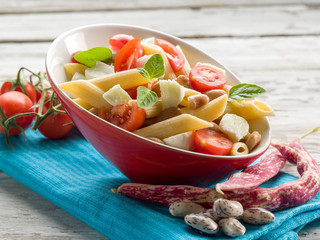 cold pasta salad with slice tomatoes mozzarella and beans
