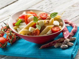 cold pasta salad with slice tomatoes mozzarella and beans