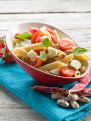 cold pasta salad with slice tomatoes mozzarella and beans