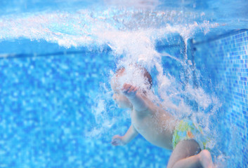 Little boy after diving into a swimming pool, hand in focus