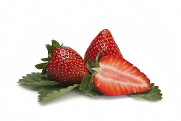 Dos fresas y una cortada sobre sus hojas en fondo blanco.