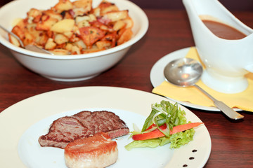 Rinder- und Schweinesteak mit Bratkartoffeln und Soße