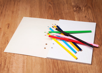 pencils and notebook on wooden table