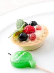 Birthday candle and fruit tart