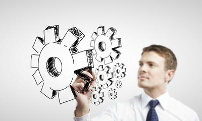 businessman drawing cog wheel