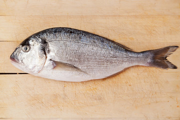 Sea bream on wooden kitchen board.