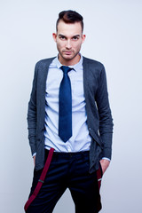 man in white shirt, tie, cardigan and trousers with suspenders