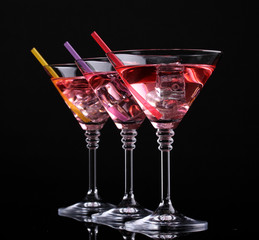 Red cocktail in martini glasses isolated on black