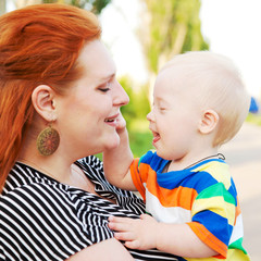 mother and baby with Down syndrome smiling, hugging and talking