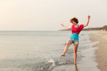 Junge Frau spaziert am Strand entlang