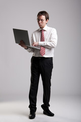 Fototapeta na wymiar Nerdy businessman holding a laptop