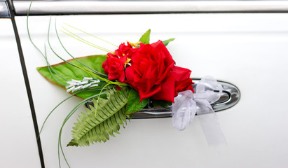 Red flower on the handle of a wedding car