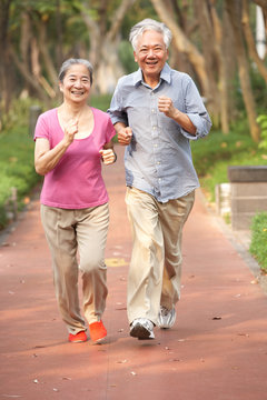 Senior Chinese Couple Jogging In Park