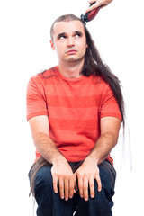 Unhappy long haired man being shaved